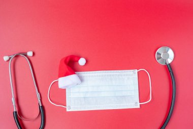 Tıbbi maskeli minyatür Noel Baba ile mutlu Noeller, koronavirüsü veya Corona Virüs Hastalığını önleyin (Covid-19). Tatil, Kutlama, Yeni Yıl, Yeni Normal ve Sağlık Konsepti