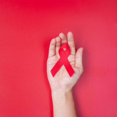 Red Ribbon 'ın elini tutarak yaşayan ve hastalığa yakalananları destekliyorum. Sağlık ve güvenli seks konsepti. Aralık Dünya Yardım Günü ve çoklu miyelom kanseri farkındalığı ayı