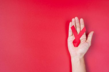 Red Ribbon 'ın elini tutarak yaşayan ve hastalığa yakalananları destekliyorum. Sağlık ve güvenli seks konsepti. Aralık Dünya Yardım Günü ve çoklu miyelom kanseri farkındalığı ayı
