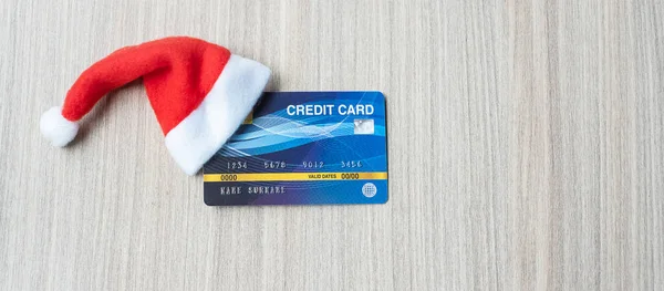 Merry Christmas with miniature Santa Clause hat and credit card on table at office. Holiday, Celebration, technology, e-commerce, Black Friday, Cyber Monday and online payment concept