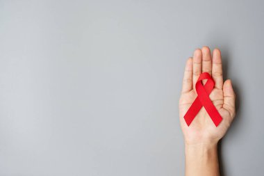 Red Ribbon 'ın elini tutarak yaşayan ve hastalığa yakalananları destekliyorum. Sağlık ve güvenli seks konsepti. Aralık Dünya Yardım Günü ve çoklu miyelom kanseri farkındalığı ayı