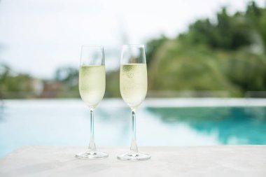 İki şampanya bardağı ya da yüzme havuzunun yanında Prosecco. Yaz seyahati, tatil, tatil ve hafta sonu konsepti