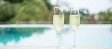 İki şampanya bardağı ya da yüzme havuzunun yanında Prosecco. Yaz seyahati, tatil, tatil ve hafta sonu konsepti