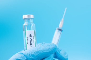 COVID-19 aşı şişesi ve Coronavirus enfeksiyonuna karşı şırınga şırıngası hastane laboratuvarında elinde Nitrile Eldiveni ile doktor elinde. Tıbbi, sağlık, aşılama ve aşılama kavramı