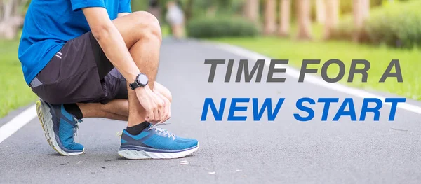 Time for A New Start with Young man tying shoelace in the park outdoor, athlete runner man ready for running and jogging in morning. Fitness, wellness, healthy lifestyle and New year New You concepts