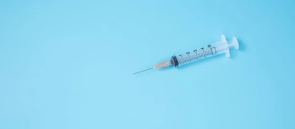 injection Needle Syringe on blue background in hospital laboratory. Medical, health, Vaccination and immunization concept