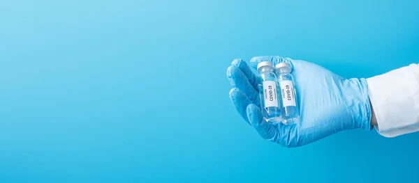 COVID-19 Vaccine vial against Coronavirus infection in hand of doctor with Nitrile Glove in hospital laboratory. Medical, health, Vaccination and immunization concept