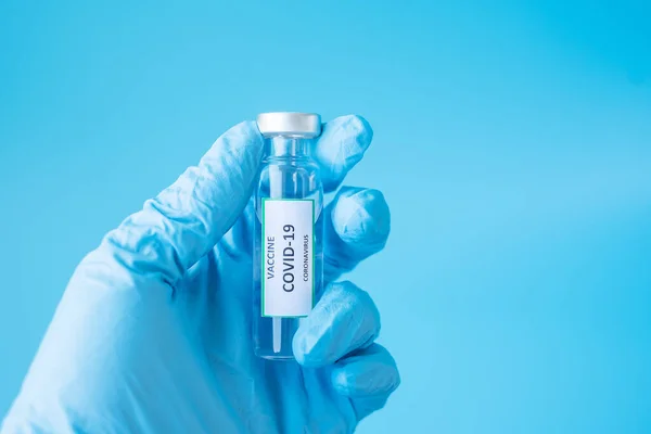 COVID-19 Vaccine vial against Coronavirus infection in hand of doctor with Nitrile Glove in hospital laboratory. Medical, health, Vaccination and immunization concept
