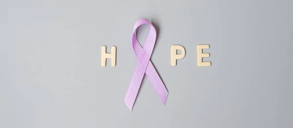 World cancer day (February 4). Lavender purple ribbon for supporting people living and illness. Healthcare and medical concept