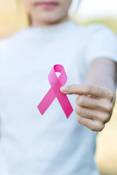 October Breast Cancer Awareness month, adult Woman hand holding Pink Ribbon for supporting people living and illness. International Women, Mother and World cancer day concept