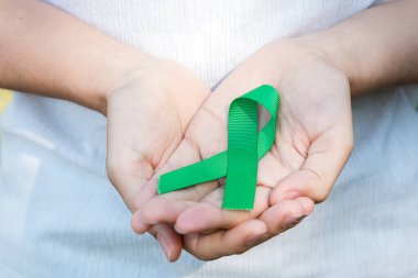Yeşil kurdele tutan bir kadın. Yaşayan ve hastalıkları desteklemek için. Karaciğer, safra kesesi safra kesesi, böbrek kanseri ve lenfoma farkındalık ayı konsepti