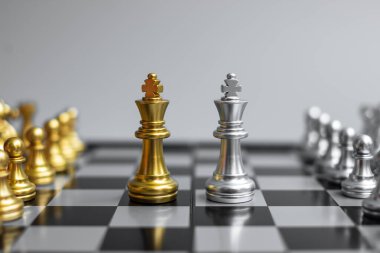 Satranç tahtası yarışmasında Altın Satranç Kralı figürü ve şah mat enerjisi ya da rakibi. Strateji, Başarı, Yönetim, İş Planlama, Taktik, Politik ve Liderlik Konsepti