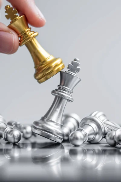 businessman hand moving gold Chess King figure and Checkmate enermy or opponent during chessboard competition. Strategy, Success, management, business planning, interruption and leadership concept