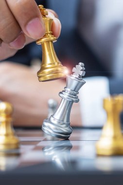 Satranç tahtası müsabakasında iş adamı eli altın satranç kralı figürü ve şah mat rakibi. Strateji, Başarı, Yönetim, iş planlaması, bozulma ve liderlik kavramı