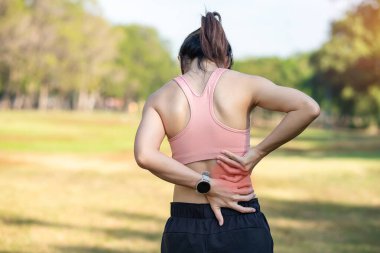 Koşarken kas ağrısı çeken genç bir kadın. Piriforis Sendromu, bel ağrısı ve omurga baskısı nedeniyle sırt ağrısı çeken bir kadın. Spor yaraları ve tıbbi konsept