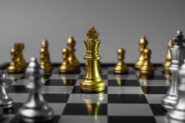 Satranç tahtasında rakip ya da düşmana karşı altın satranç kralı figürü. Strateji, çatışma, yönetim, iş planlaması, taktik, siyaset, iletişim ve lider konsepti