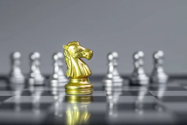 Gold  Chess Knight (horse) figure on Chessboard against opponent or enemy. Strategy, Conflict, management, business planning, tactic, politic, communication and leader concept