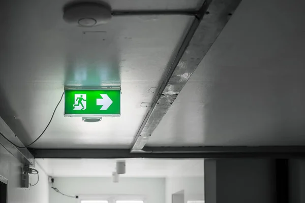 Fire Emergency exit sign on the wall background inside building. Safety concept