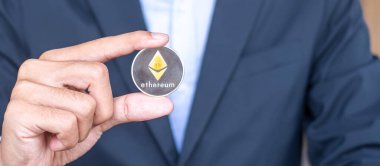 Kripto, gümüş Ethereum (ETH) kripto para birimini elinde tutan iş adamı, engelleme ağı içinde Dijital Para, teknoloji ve çevrimiçi internet takası kullanılarak takas edilir. Mali konsept