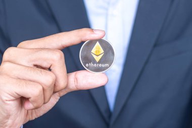 Kripto, gümüş Ethereum (ETH) kripto para birimini elinde tutan iş adamı, engelleme ağı içinde Dijital Para, teknoloji ve çevrimiçi internet takası kullanılarak takas edilir. Mali konsept