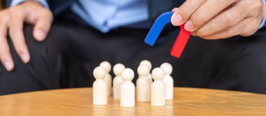 İş adamı mıknatısı tutuyor ve kalabalık çalışanından ahşap bir figür çıkarıyor. İş, İnsan Kaynakları Yönetimi, İşe Alma, Takım Çalışması, Strateji, Zehirli İnsanlar ve Liderlik Kavramları