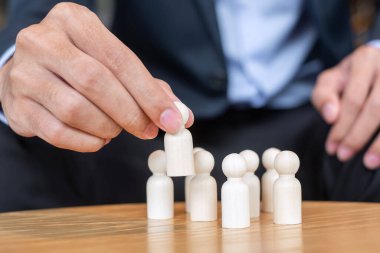 İşadamı, işçi kalabalığından lider ahşabı çekiyor. Toksik İnsanlar, İnsan Kaynakları Yönetimi, İşe Alma, Takım Çalışması ve Liderlik Konseptleri