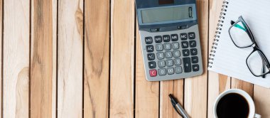 Hesap makinesi, kalem, gözlük, boş defter ve arka planda kahve fincanı olan ofis masası. metin kavramı için kopyalama alanı olan çalışma alanı veya ev ofisi