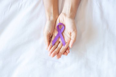Pankreas kanseri, dünya alzaymır, epilepsi, lupus ve aile içi şiddet günü farkındalık ayı, yaşayan insanları desteklemek için mor kurdele tutan kadın. Sağlık ve Dünya Kanser Günü konsepti