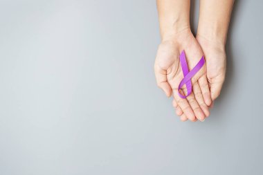 Pankreas kanseri, dünya alzaymır, epilepsi, lupus ve aile içi şiddet günü farkındalık ayı, yaşayan insanları desteklemek için mor kurdele tutan kadın. Sağlık ve Dünya Kanser Günü konsepti