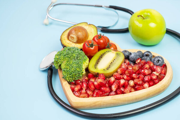 фрукты и овощи; черника, помидоры вишни, авокадо, брокколи, киви и зеленое яблоко на голубом фоне. потеря веса, питание, здоровое питание, диета и вегетарианская концепция