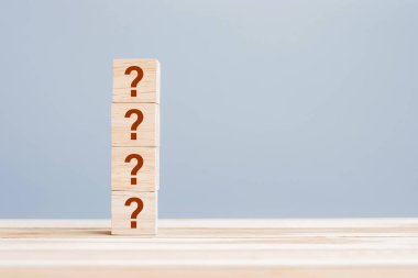 Soru işareti (?) Masa arkasındaki tahta küp blokta. SSS (sıklıkla sorulan sorular), Yanıt, Soru ve Cevap, Bilgi, İletişim ve Sorgulama Kavramları