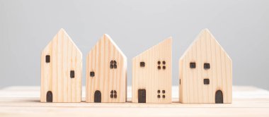 Masa arkasında ahşap ev modeli. Ev, Kriz, Ekonomik Durgunluk, Evsiz, Gayrimenkul, Alış veya Kira ve Emlak kavramı