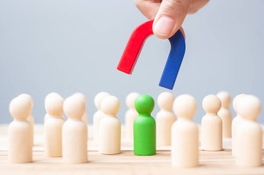 İş adamı mıknatısı tutuyor ve kalabalık çalışanından ahşap bir figür çıkarıyor. İş, İnsan Kaynakları Yönetimi, İşe Alma, Takım Çalışması, Strateji, Zehirli İnsanlar ve Liderlik Kavramları