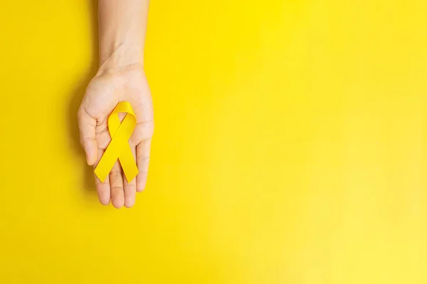 Mão Segurando Fita Amarela Fundo Amarelo Para Apoiar Pessoas Que — Fotografia de Stock