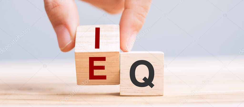 Business man hand change wooden cube block from IQ to EQ, balance between intelligence quotient and emotional intelligence concepts