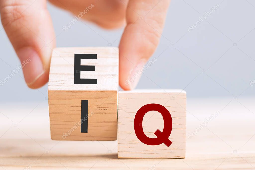 Business man hand change wooden cube block from IQ to EQ, balance between intelligence quotient and emotional intelligence concepts