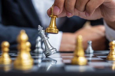 Satranç tahtası müsabakasında iş adamı eli altın satranç kralı figürü ve şah mat rakibi. Strateji, Başarı, Yönetim, iş planlaması, bozulma ve liderlik kavramı