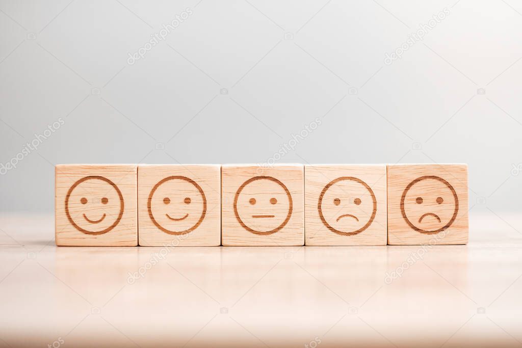 emotion face symbol on wooden blocks. Service rating, ranking, customer review, satisfaction, evaluation and feedback concept