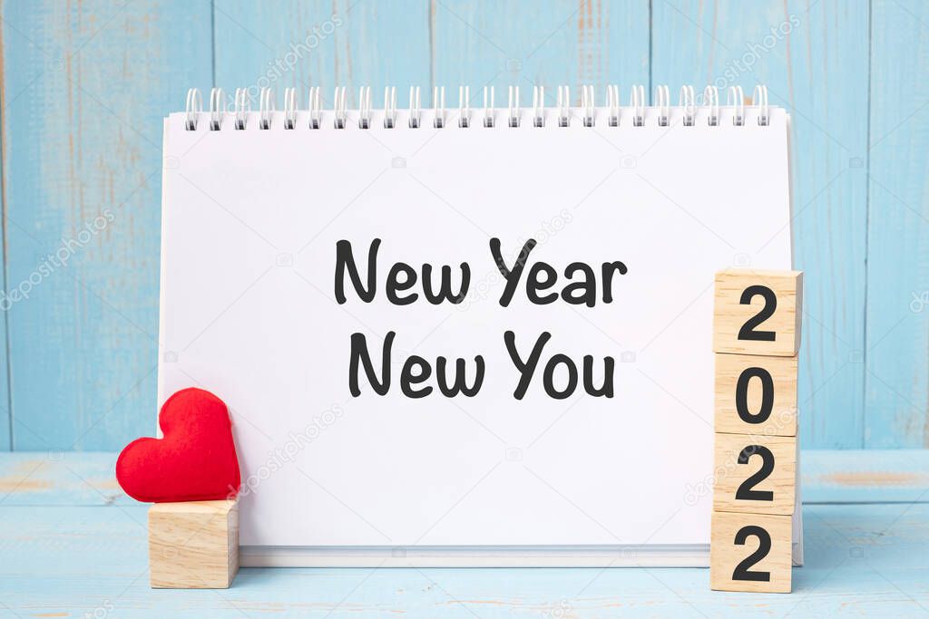 New Year New You words and 2022 cubes with red heart shape decoration on blue wooden table background. Goal, Resolution, health, Love and Happy Valentine day concept