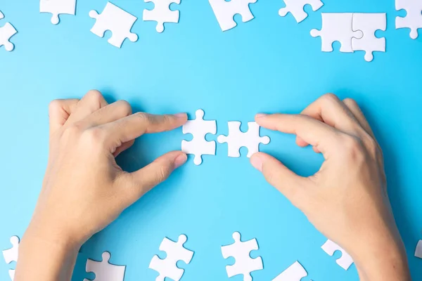 Hände Die Ein Paar Weiße Puzzleteile Auf Blauem Hintergrund Verbinden — Stockfoto