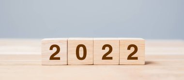 Masa arkasında 2022 tahta küp blok var. Çözüm, plan, gözden geçirme, hedef, başlangıç ve yeni yıl tatili kavramları