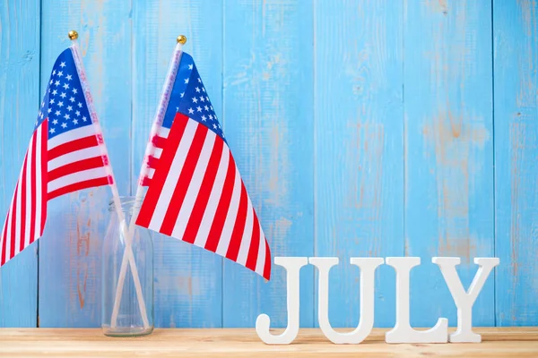 木製のテーブルの背景に7月のテキストとアメリカのフラグ アメリカの独立とお祝いの概念の休日 — ストック写真