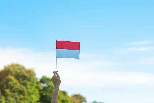 Χέρι Κρατώντας Σημαία Της Ινδονησίας Μπλε Φόντο Του Ουρανού Ημέρα — Φωτογραφία Αρχείου