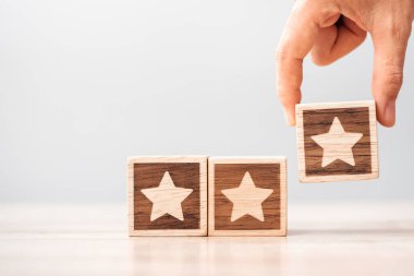 Adam el ele tutuşuyor. Müşteri, kullanıcı değerlendirmeleri için reytingleri seçer. Hizmet derecesi, sıralama, müşteri değerlendirmesi, memnuniyet, değerlendirme ve geri bildirim kavramı