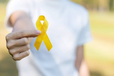 İntihar önleme, sarkoma, kemik, mesane, çocuk kanseri farkındalığı ayı, yaşayan ve hastalıkları desteklemek için sarı kurdele. Çocuk Sağlığı ve Dünya Kanser Günü konsepti