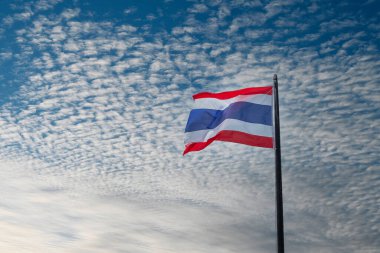 Mavi gökyüzü arka planında dalgalanan Tayland bayrağı