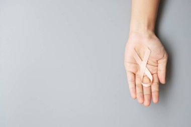 Eylül ayı rahim kanseri farkındalığı ayı, Peach Ribbon 'ı elinde tutan kadın yaşayan ve hastalıkları desteklediği için. Sağlık ve Dünya Kanser Günü konsepti