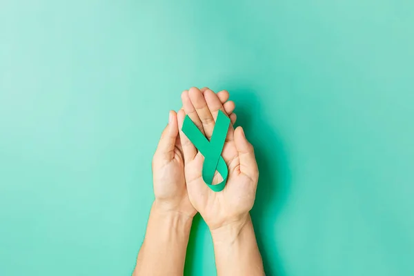 September Ovarian cancer Awareness month, Woman holding teal Ribbon color for supporting people living, and illness. Healthcare and world cancer day concepts