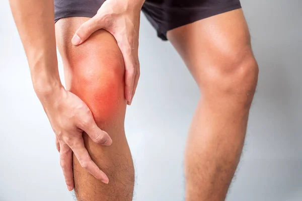 Gri arka planda kas ağrısı olan bir adam. Runners Knee veya Patellofemoral Pain Sendromu, osteoartrit, romatizma, romatizma ve Patellar Tendinitis nedeniyle yaşlıların diz ağrısı vardır. tıbbi konsept