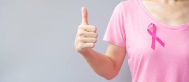 Ekim Kanser Farkındalık Ayı, pembe tişörtlü yaşlı kadın ve canlı ve hastalıkları desteklemek için başparmak işareti. Uluslararası Kadınlar, Anne ve Dünya Kanser Günü Konsepti